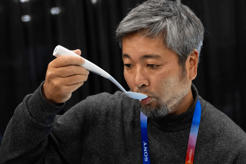 A person testing the Kirin Electric Salt Spoon, a gadget designed to enhance flavors in food without adding salt.