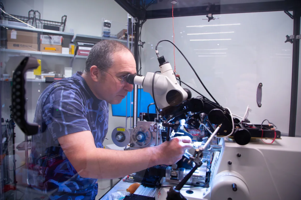 A scientist working intently with a microscope and laboratory equipment in a research setting.