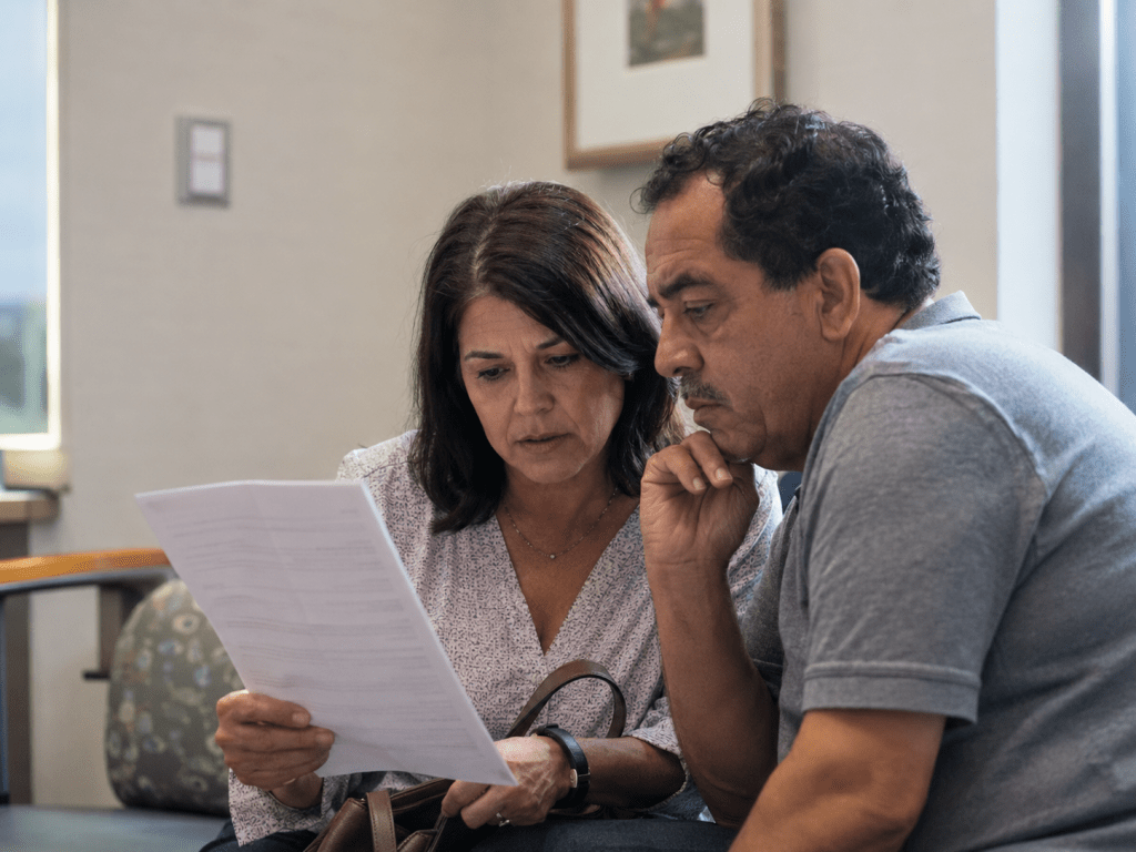 Patient and caregiver reviewing written cancer care documents after an oncology visit.